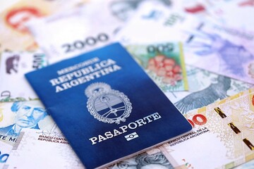 Argentine passport lies on Argentina pesos money bills close up. Travel and citizenship