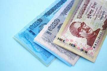 Bangladeshi taka money bills in big amount lies on teal color table close up