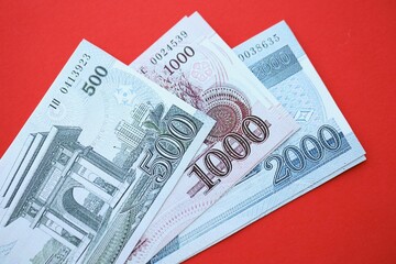 North Korean won money bills in big amount lies on red color table close up