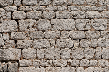 Fototapeta premium The texture of stone walls of the basilica in Hidirli Ruins, is located 2.5 km north of Kızkalesi in Mersin, Southern Turkey.