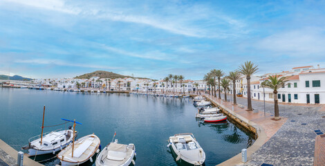 Picturesque Fornells Harbor With Boats, White Buildings And Palm Trees. Menorcan Fishing Village, Balearic Islands Waterfront, Spanish Tourism