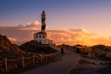 Dramatic Sunset Over Favaritx Lighthouse And Rugged Coastal Landscape. Menorca Landmark, Striking Sky, Balearic Islands Scenery, Golden Hour