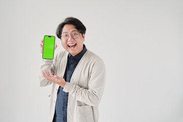 A man is holding a green phone. He is smiling. The man is wearing glasses
