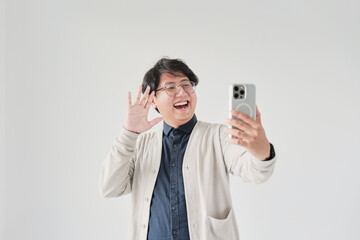 A man is smiling and holding a cell phone