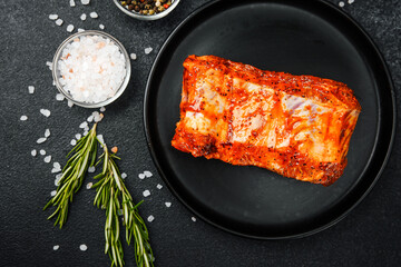 Spicy pork ribs on black plate with rosemary and salt