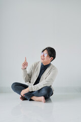 A man is sitting on the floor with his hands on his knees