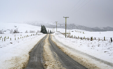 Tire tracks on a snow-covered slippery road. Ashburton Lakes. South Island.