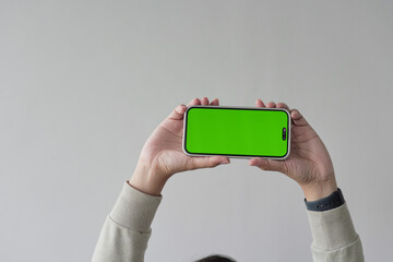 A person is holding a green iPhone