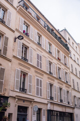 Facade of Parisian Apartment Building with White Shutters and Balconies