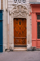 Unique Carved Wooden Door with Diamond Pattern and Ornate Stone Frame