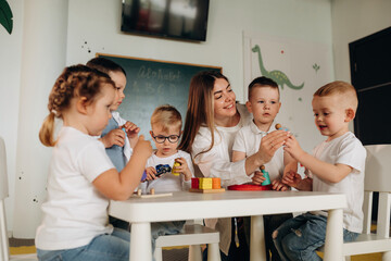 Having fun by learning. Children in kindergarten with their teacher