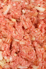 Slose-up shot captures the texture of a well-mixed raw stuffing, featuring ground meat, uncooked rice, and chopped onions, ready for preparing stuffed pepper