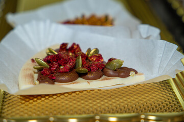 Luxurious handmade decorative chocolates in a display case of assorted pralines with selective accent.