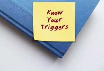 Book with text written note KNOW YOUR TRIGGERS, identifying specific stimuli that cause strong...