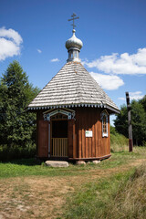 A small wooden building with a pointed roof and a cross on top