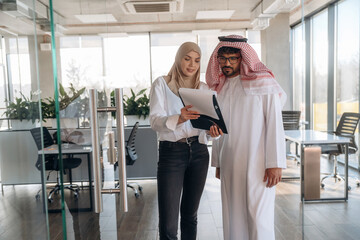 Muslim man and woman are indoors in modern building