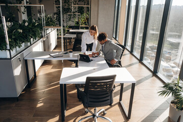 Illuminated by sunlight. Man and woman are indoors in modern building