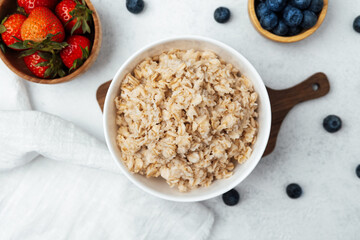 Bright kitchen with oatmeal, strawberries, and blueberries bowl