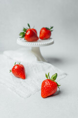 Fresh strawberries displayed on a cake stand with a light background