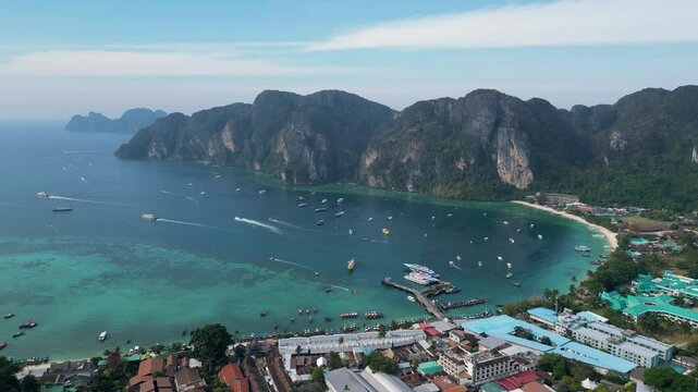 Stunning aerial of Phi Phi Don showing turquoise waters, limestone cliffs, and boats in the vibrant bay.