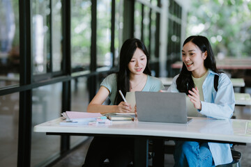 two asian student walking on campus