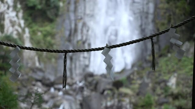 Close up of shide papers hanging on rope in front of Nachi Falls in Nachikatsuura, Japan
