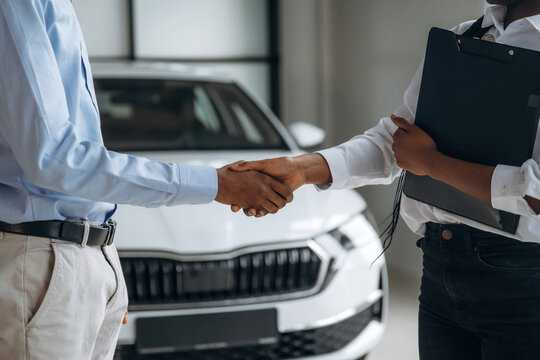 Fototapeta Deal has made, happy new owner. Car seller is assisting client in the automobile salon