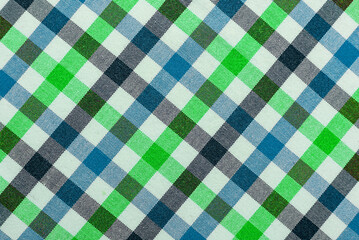 The texture of linen fabric in a large cage of blue, green, brown and white. Scottish tailoring material. Checkered fabric