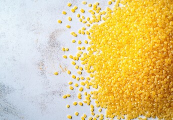 Pile of golden yellow granules on light gray surface