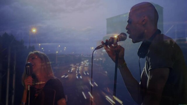 Male singer gripping mic starting verse female singer harmonizing ending song with light trails
