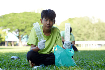 Asian boy is a student in the Environmental Club and his friends help collect and sort waste plastic water bottles and glass bottles for recycling or reuse. In the concept of saving the world.