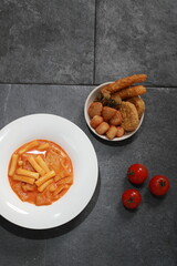 Korean Rose Tteokbokki, a creamy spicy rice cake dish topped with cheese, served with assorted...