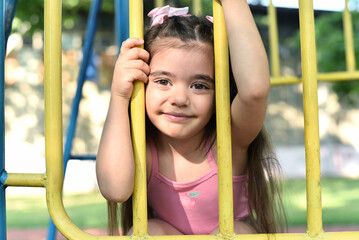 Fototapeta premium Little girl of 4 years old is playing on the playground in the park.