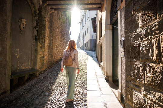 Fototapeta Tourist exploring Citta Alta streets in Bergamo, Italy. Vacation in European ancient city. Solo travel lifestyle concept