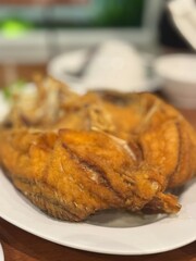 Golden crispy deep-fried whole sea bass, a popular Thai dish known for its crunchy skin and tender white meat. Often served with a flavorful fish sauce dressing or as a standalone crispy fried fish.