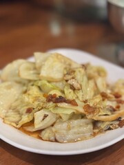 Classic Thai stir-fried cabbage with fish sauce and crispy pork bits "Gaeng Pli Pad Nam Pla, a simple yet incredibly flavorful and aromatic side dish or main course, known for its sweetness.