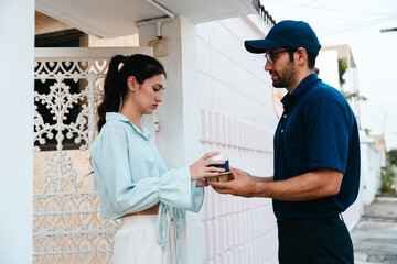 Obraz premium A woman picks up coffee, a burger and snacks from a drive-thru worker in front of her house during rush hour