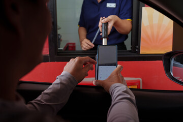 Obraz premium Scan and pay for food, pick up food from a drive-thru counter and take it to eat at home and at work.