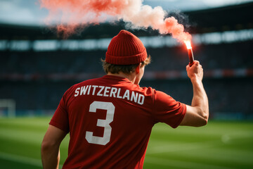 Swiss Fan in Red Beanie Holding Flare at Stadium

