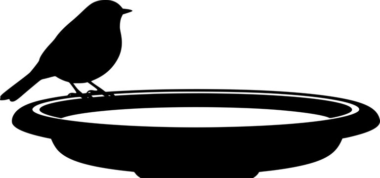 Silhouette of a Bird Resting on a Bird Bath in stark contrast