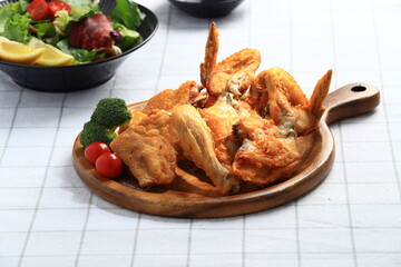 A popular Korean-style fried chicken dish featuring crispy wings and drumettes, served with fresh salad. Perfect as a meal or bar snack.
