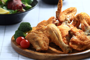 A popular Korean-style fried chicken dish featuring crispy wings and drumettes, served with fresh salad. Perfect as a meal or bar snack.