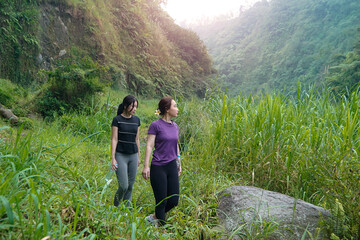 Asian Women Hiking in Lush Green Valley, Embracing Sport, Exercise, Sustainable Outdoor Lifestyles