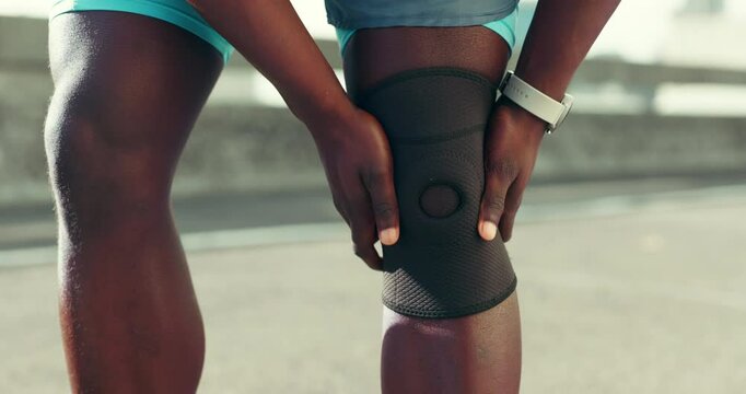 Fitness, hands and knee brace with person outdoor in city for cardio, running or workout routine. Exercise, injury and joint pain with athlete on bridge downtown for recovery or rehabilitation