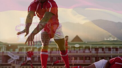 Red-jerseyed rugby player securing ball from ruck at sunset enabling animated pass arc for support - Powered by Adobe