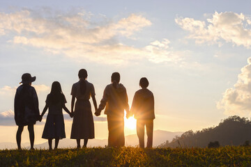 Five little girls are holding hands and watching the sunset on mountain