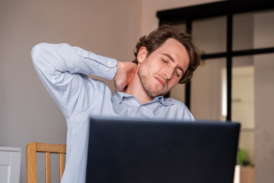 Seated man stretching during work to relieve muscle stiffness