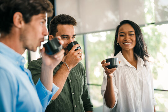 Diverse people executive specialists startup coworkers discussing news, drinking tea,coffee in break