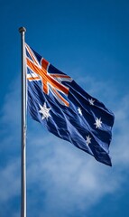 Obraz premium A waving Australian flag against a clear blue sky.