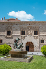 Obraz premium Estatua de madre y niño con el palacio de los Momos de fondo en Zamora, España